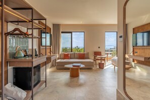Una habitación de hotel moderna con sofá, mesa de centro y zona de comedor.