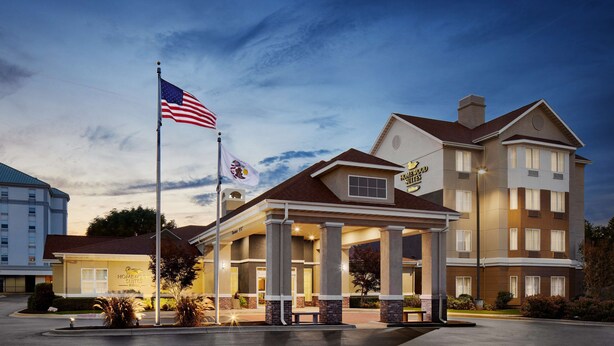 Un hotel con una destacada bandera estadounidense, una entrada bien iluminada y un letrero que indica que es el Hotel Woodrow Wilson.