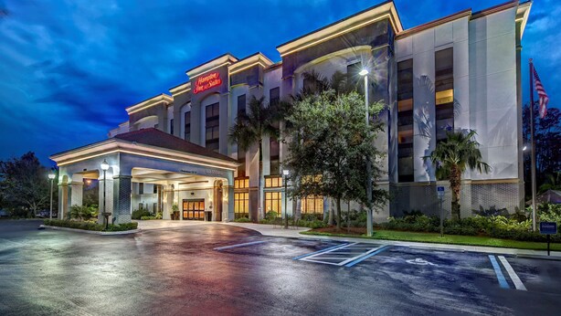 A modern hotel with a prominent entrance, a well-lit facade, and a parking lot. - Hampton Inn & Suites Fort Myers-Estero/FGCU (Estero)