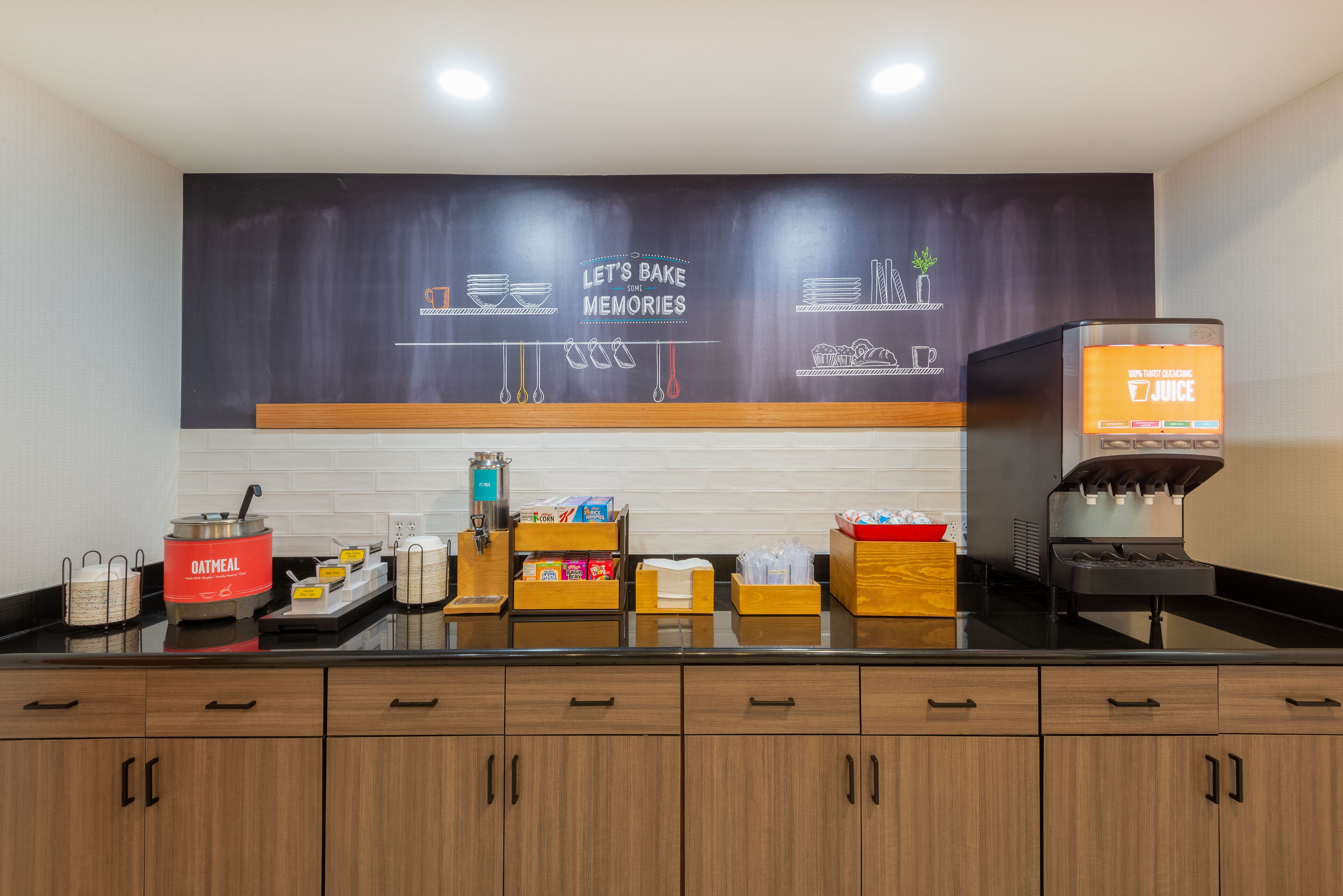 A kitchen area with a coffee machine, a chalkboard with a baking theme, and various kitchen utensils.