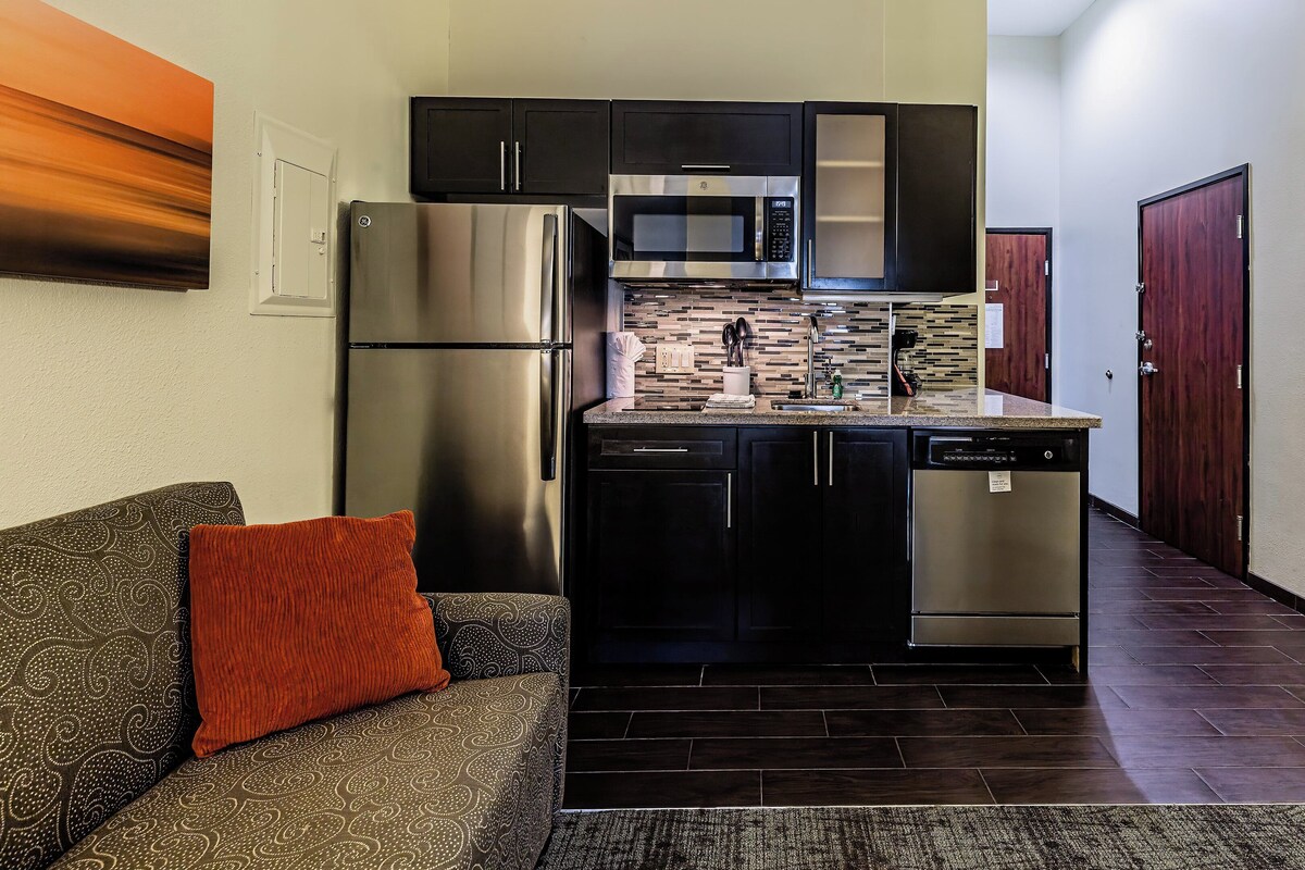 A compact kitchen with a refrigerator, microwave, and dishwasher.