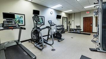 A gym with treadmills, an elliptical, and free weights.