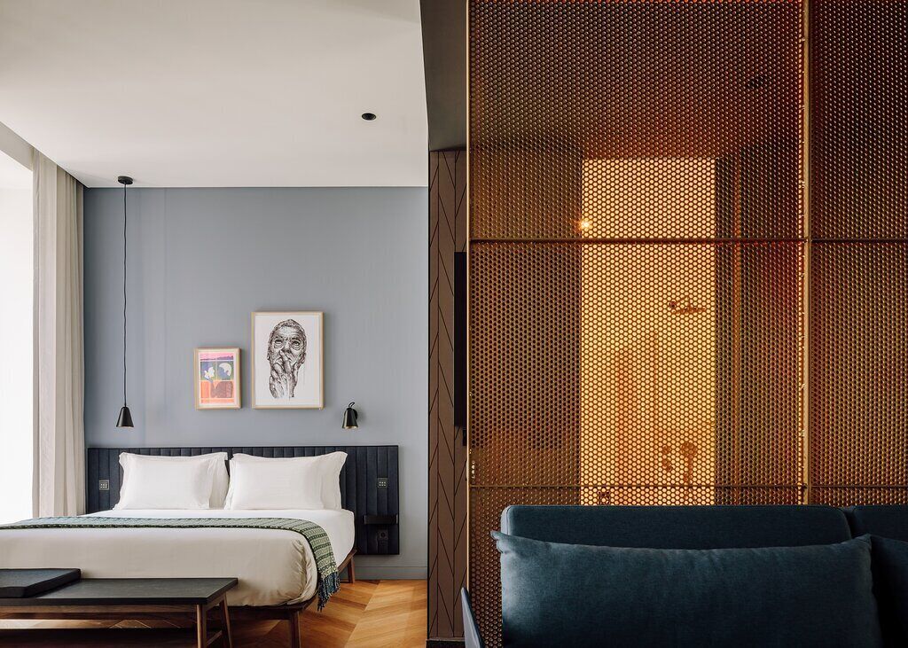 Ein modernes Hotelzimmer mit Bett, Schreibtisch und Sitzecke.
