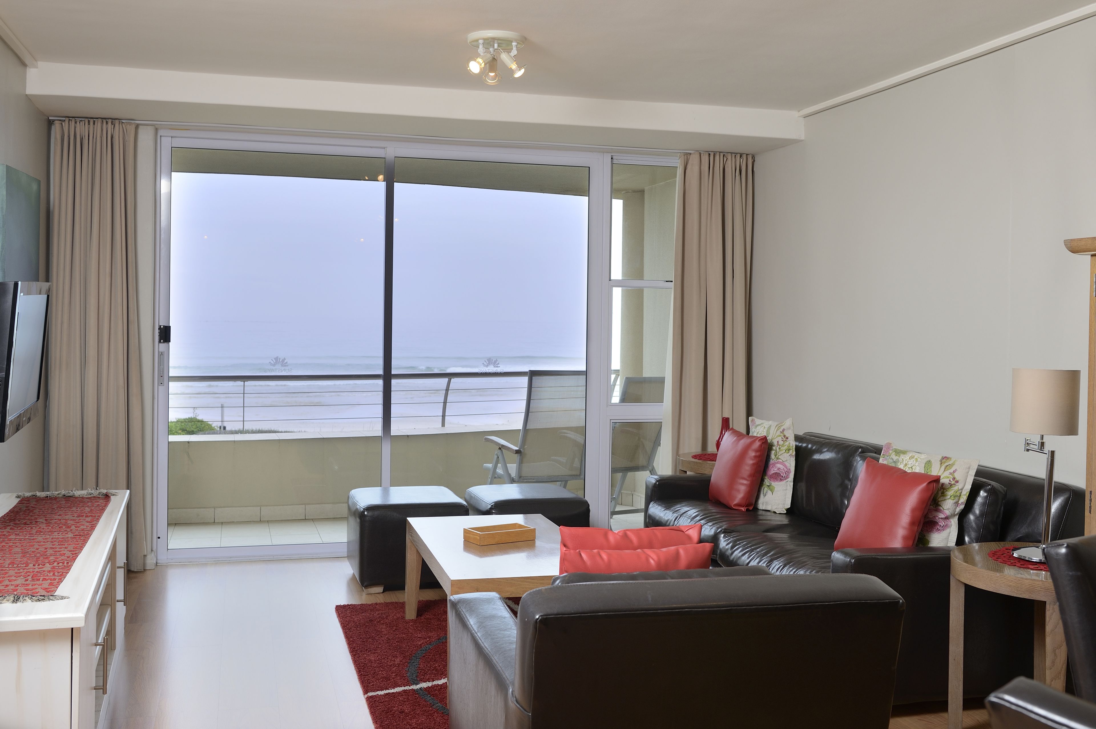 A modern living room with a sofa, coffee table, and a TV.