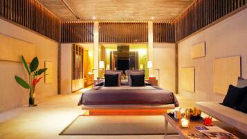 A modern hotel room with a large bed, a seating area, and a view of the city.