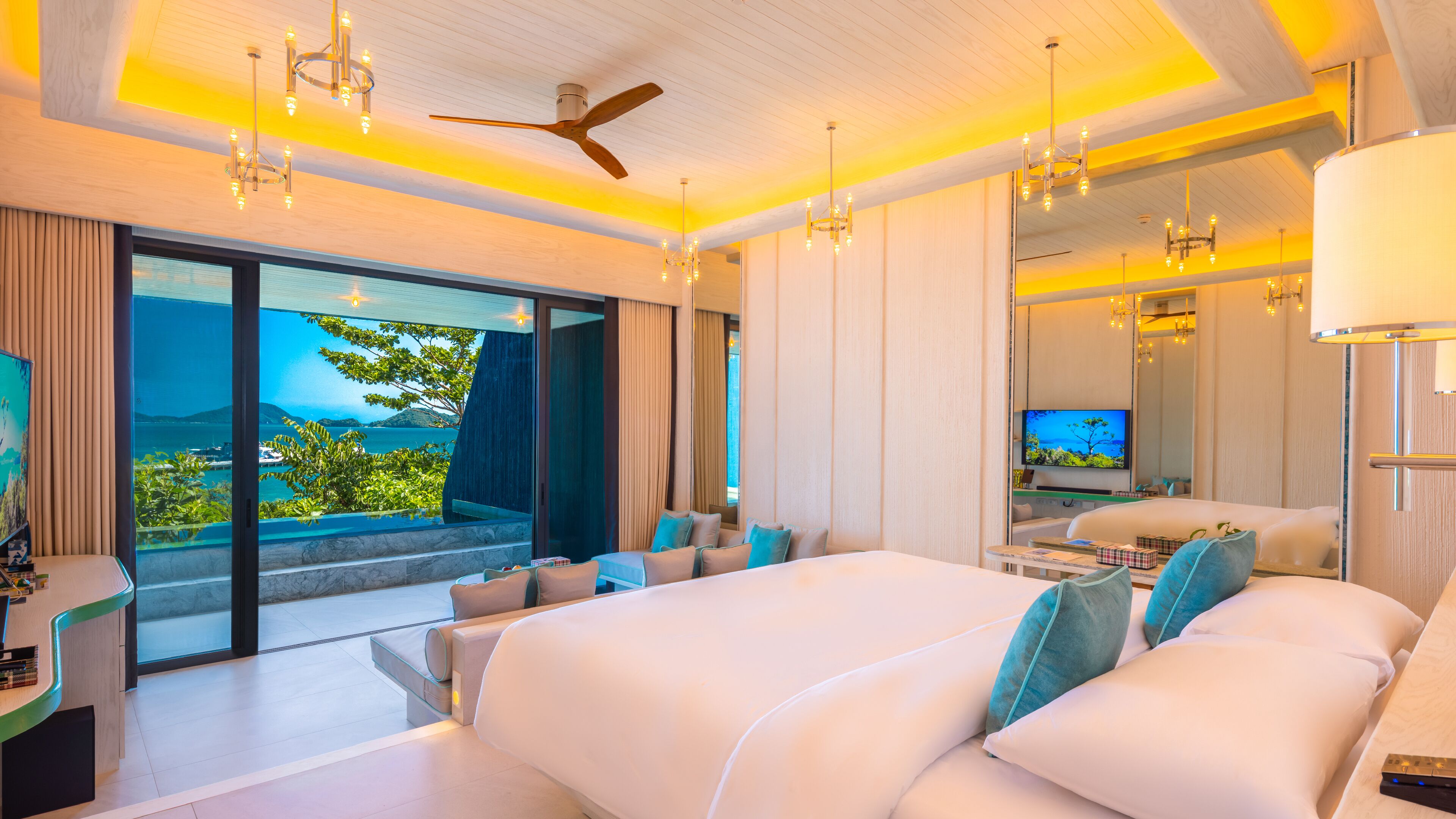 Una habitación de hotel moderna con una cama grande, televisión y balcón con vista al mar.