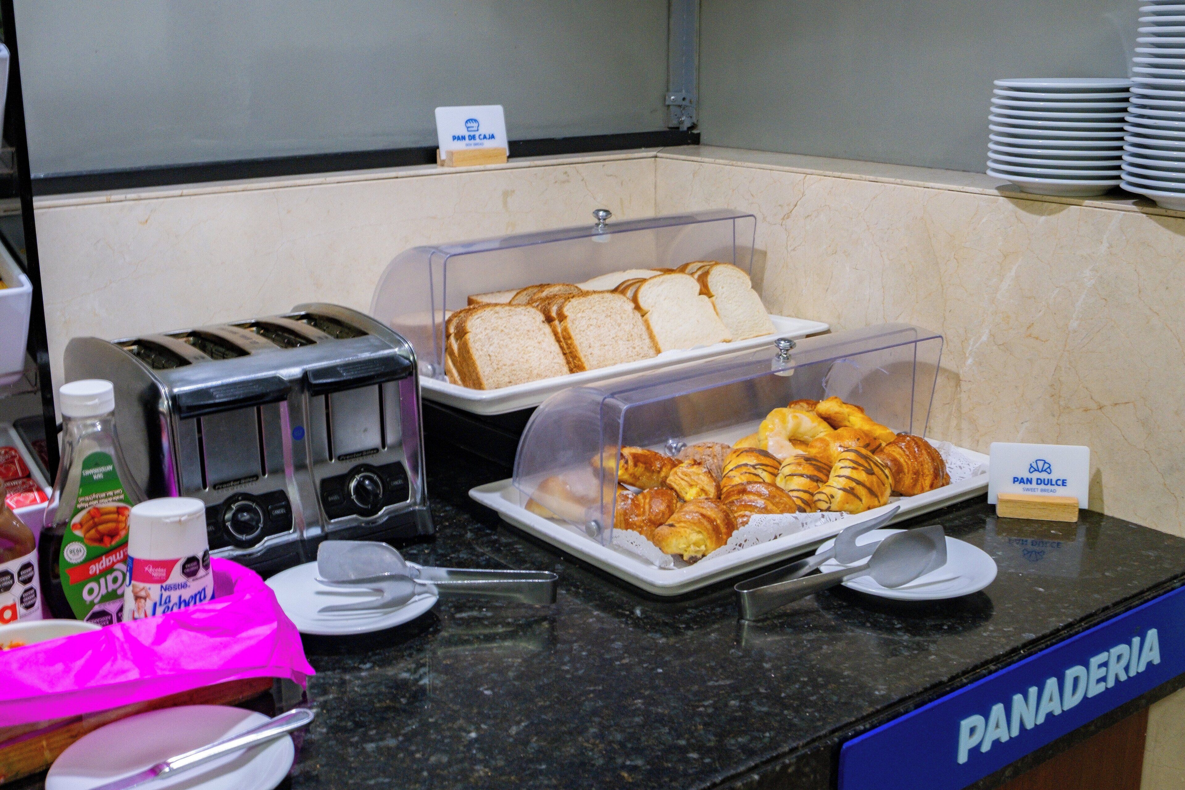 Ein reichhaltiges Frühstücksbuffet mit Brot, Croissants und Saft.