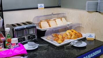 Ein reichhaltiges Frühstücksbuffet mit Brot, Croissants und Saft.