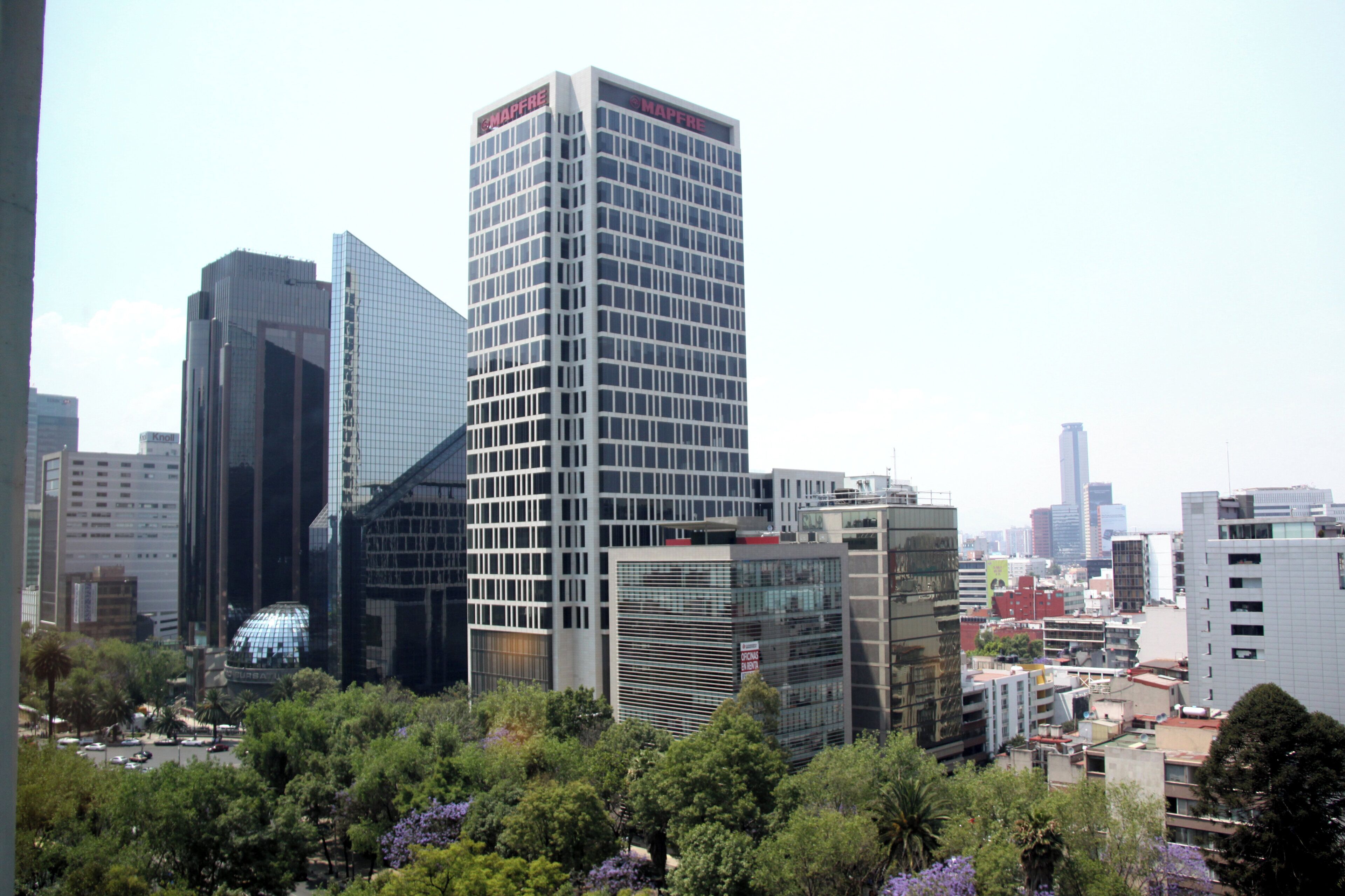 Un paisaje urbano con edificios modernos altos, incluyendo un destacado edificio de MAPFRE.