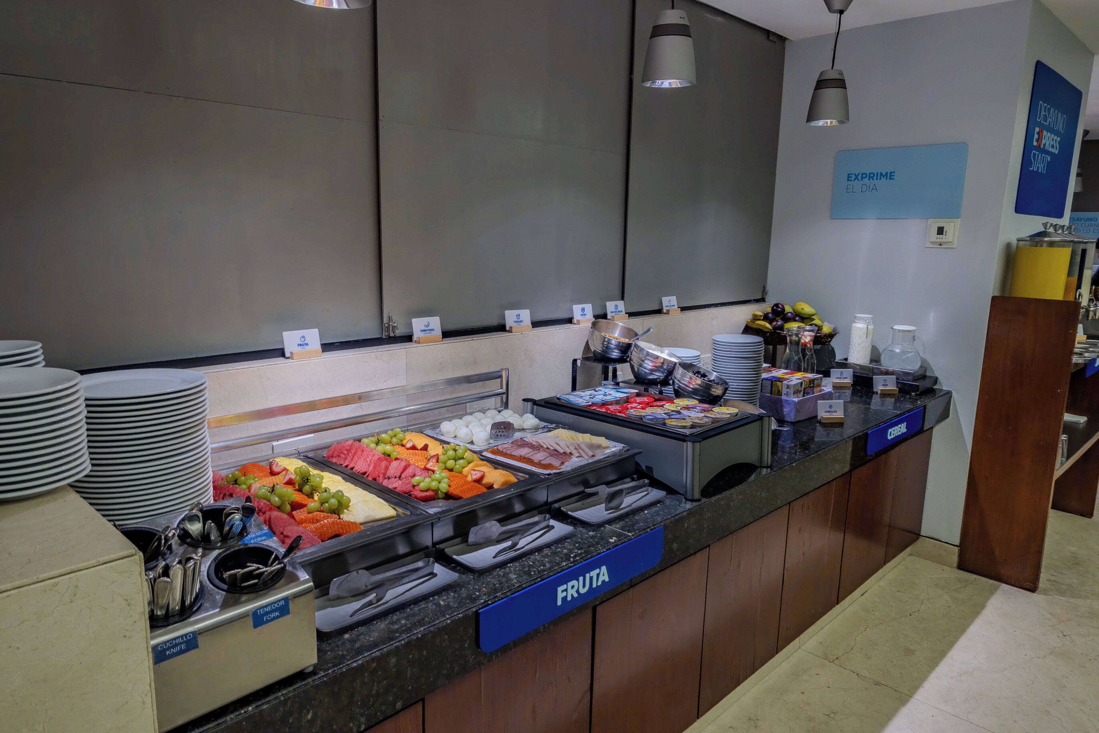 Zona de buffet con secciones identificadas para frutas y cereales.