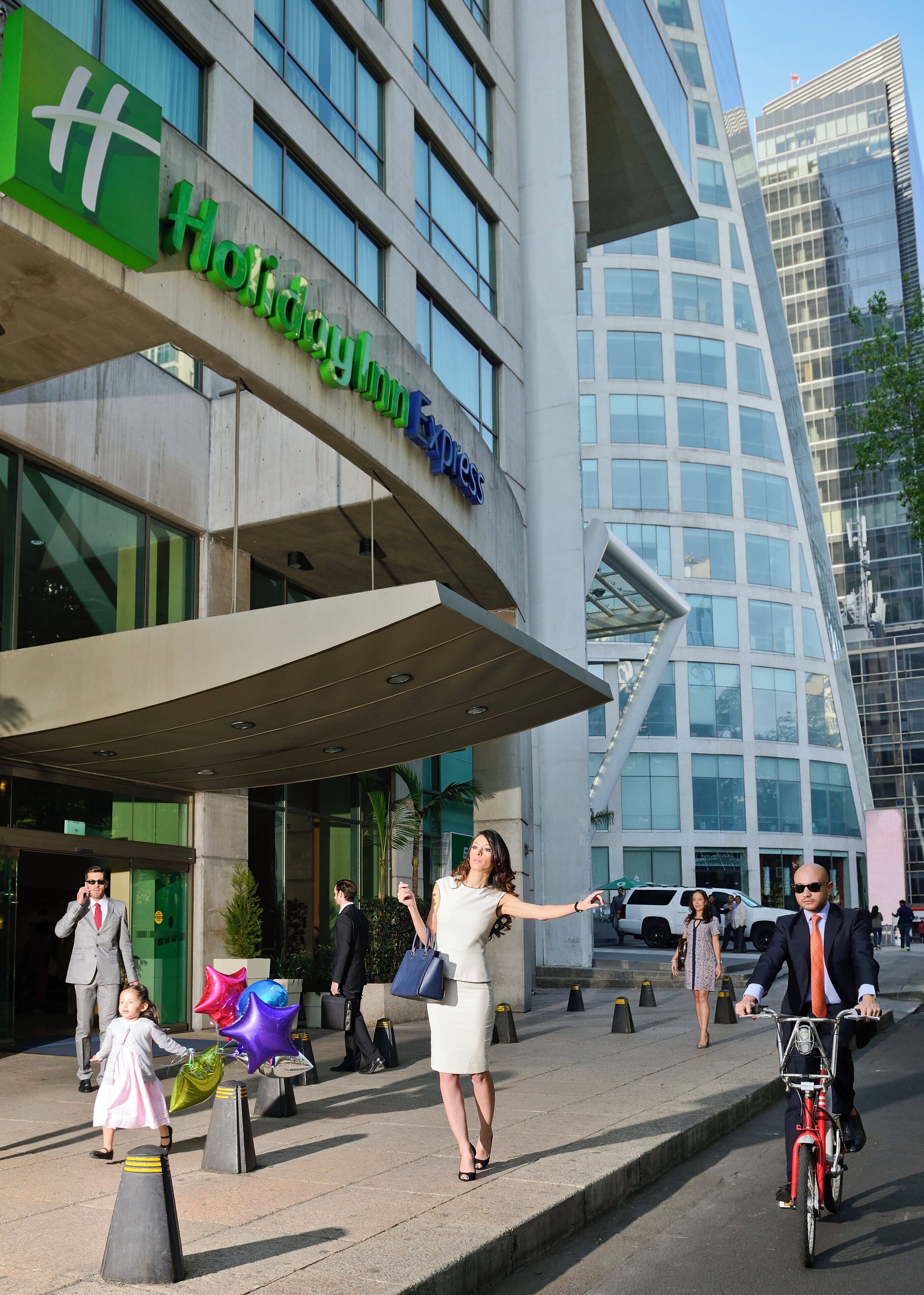 A modern building with a Holiday Inn Express sign, featuring a curved glass facade and a flat roof.
