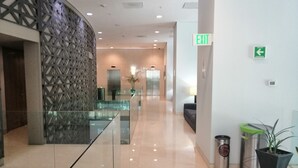 A modern lobby with a glass partition, a reception desk, and an exit sign. - Holiday Inn Express Mexico Reforma by IHG (Mexico City)