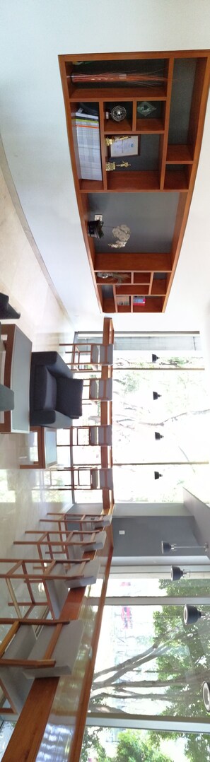 Un interior moderno con estructura de techo de madera, un sofá y vistas al exterior.