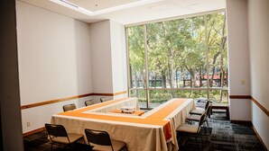 A conference room with a long table, chairs, and a large window with a view of trees and buildings. - Holiday Inn Express Mexico Reforma by IHG (Mexico City)