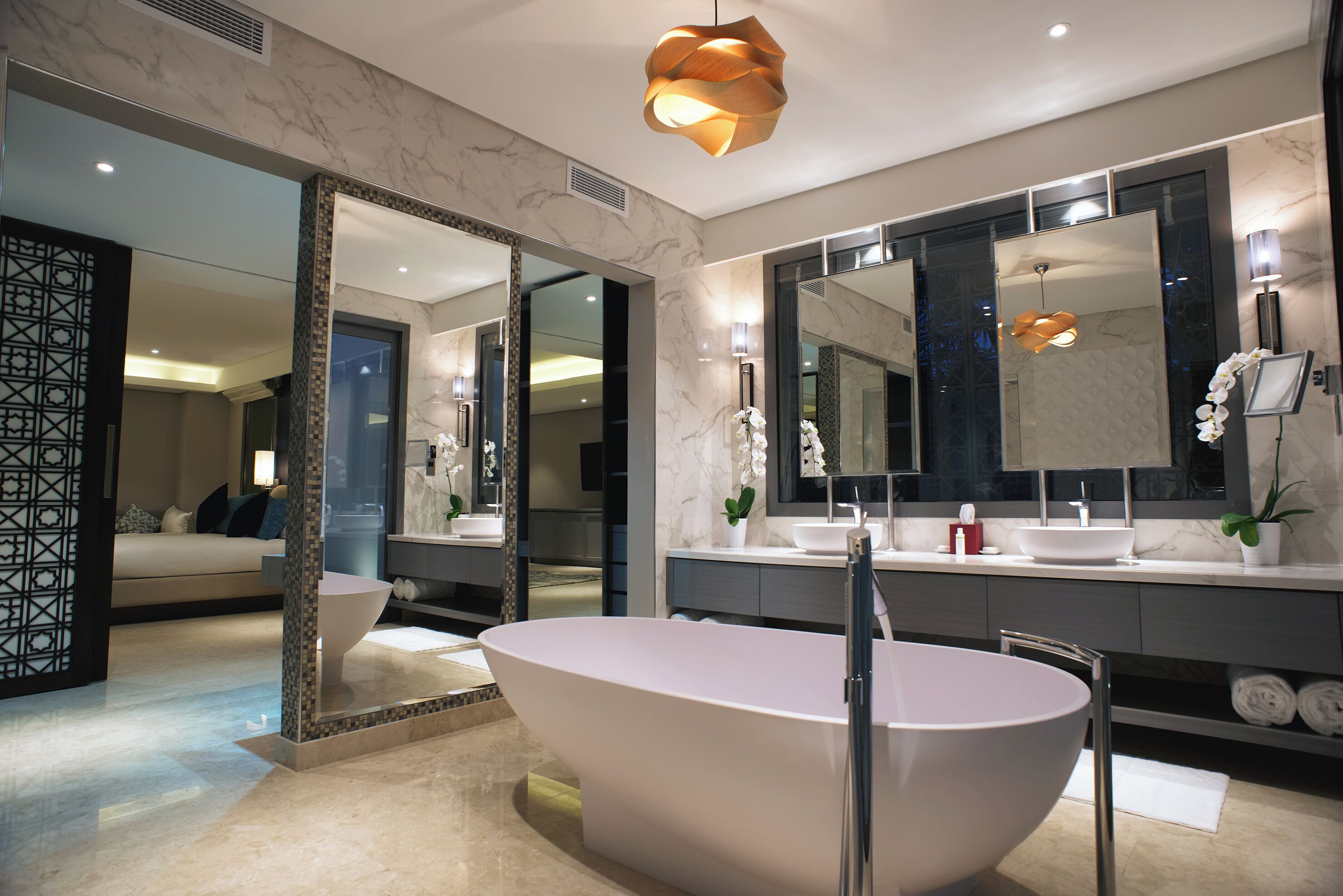 A modern bathroom with a freestanding bathtub, large mirrors, and a contemporary design.