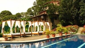 A pool area with a wooden deck, lounge chairs, and potted plants. - La Catalina Hotel and Suites (Jesús)