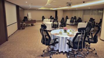 A conference room with round tables, black office chairs, and a whiteboard.