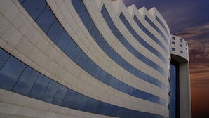 A modern building with a curved facade and large windows. - Mövenpick Hotel Qassim (Buraydah)
