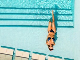 Una piscina al aire libre, sillones reclinables de piscina