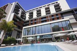 Una piscina al aire libre, sillones reclinables de piscina