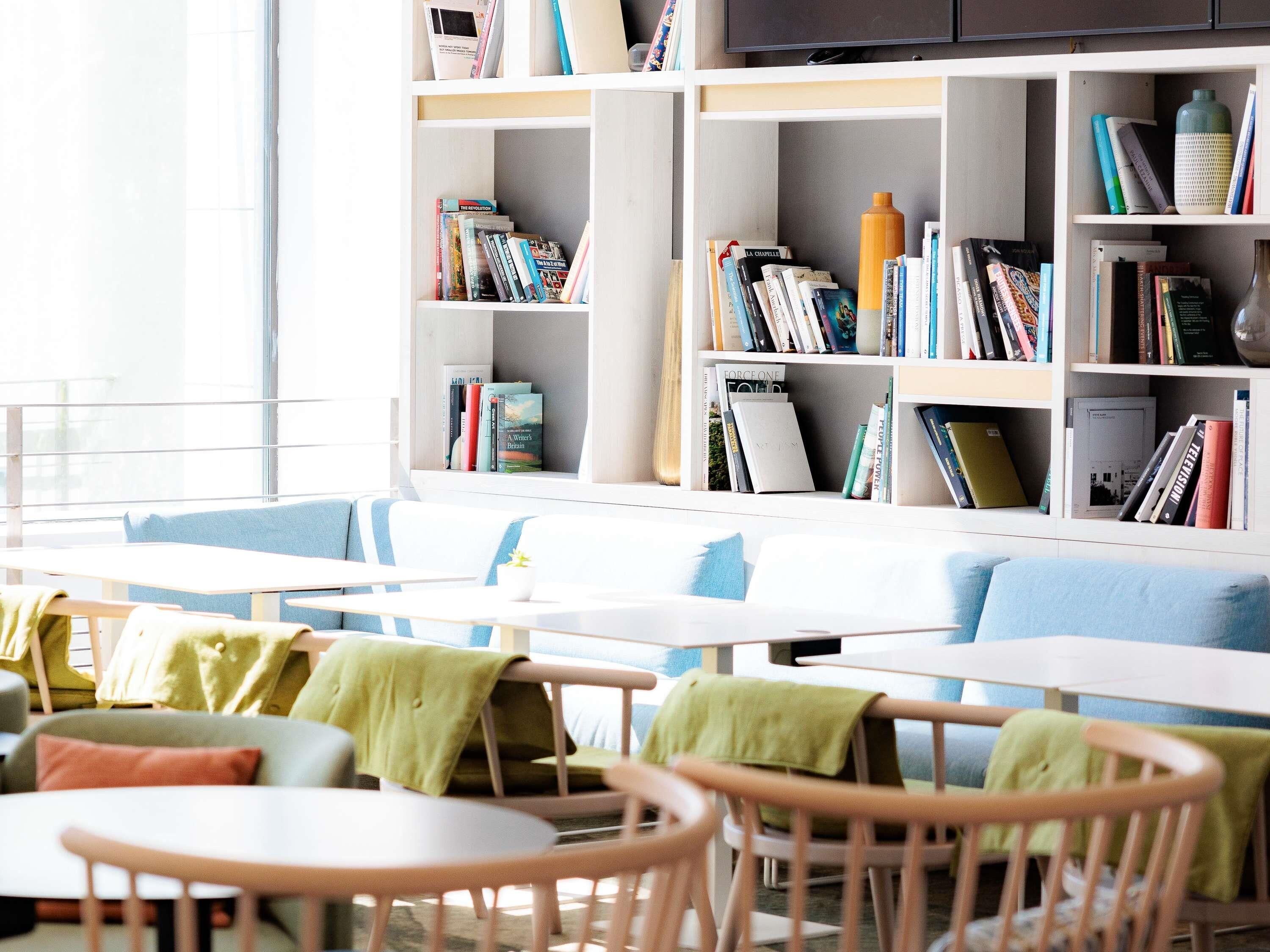 Una biblioteca moderna con estanterías, mesas y sillas.
