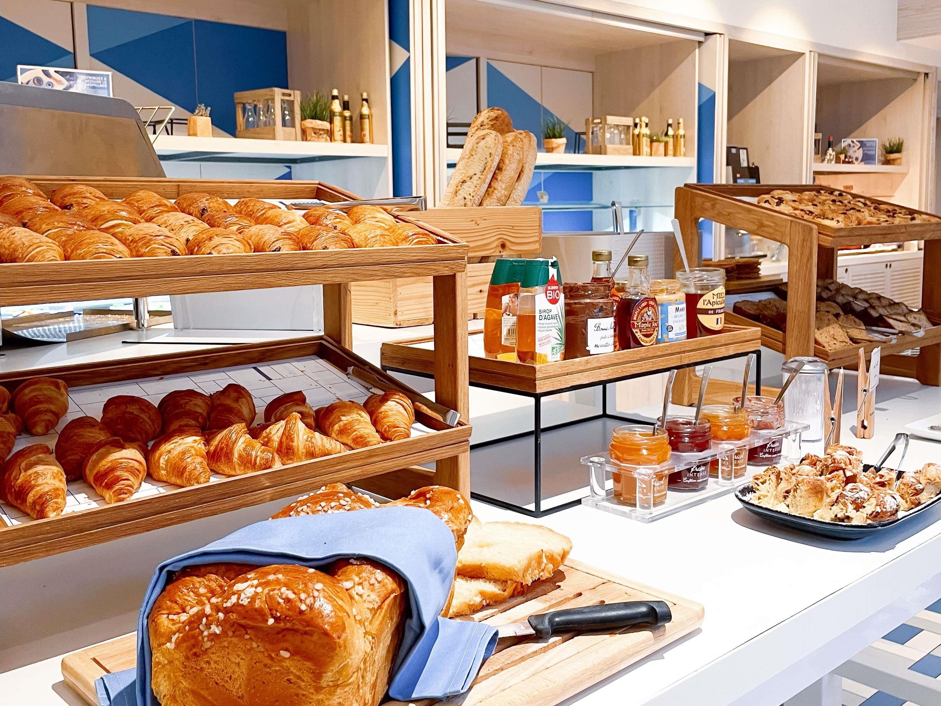 A breakfast buffet with various pastries, bread, and condiments.