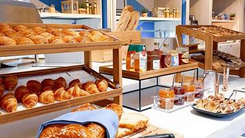 A breakfast buffet with various pastries, bread, and condiments.