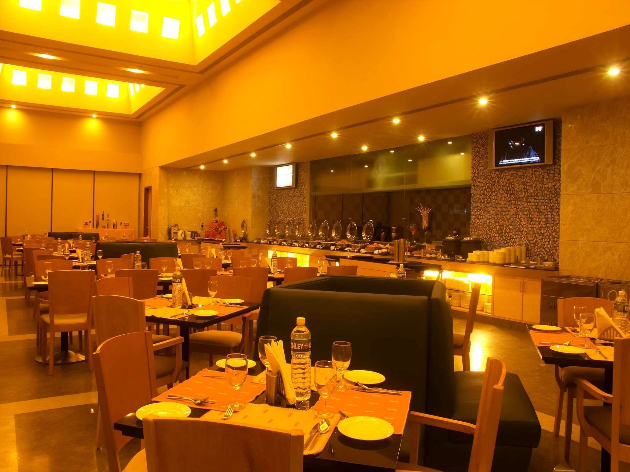 Un comedor de hotel con varias mesas, sillas y una barra.