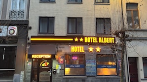 A hotel with a reception area, multiple windows, and a sign indicating it is open. - Hotel Albert (Brussels)