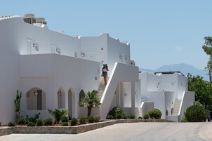 A modern white building with arched windows and a central staircase.