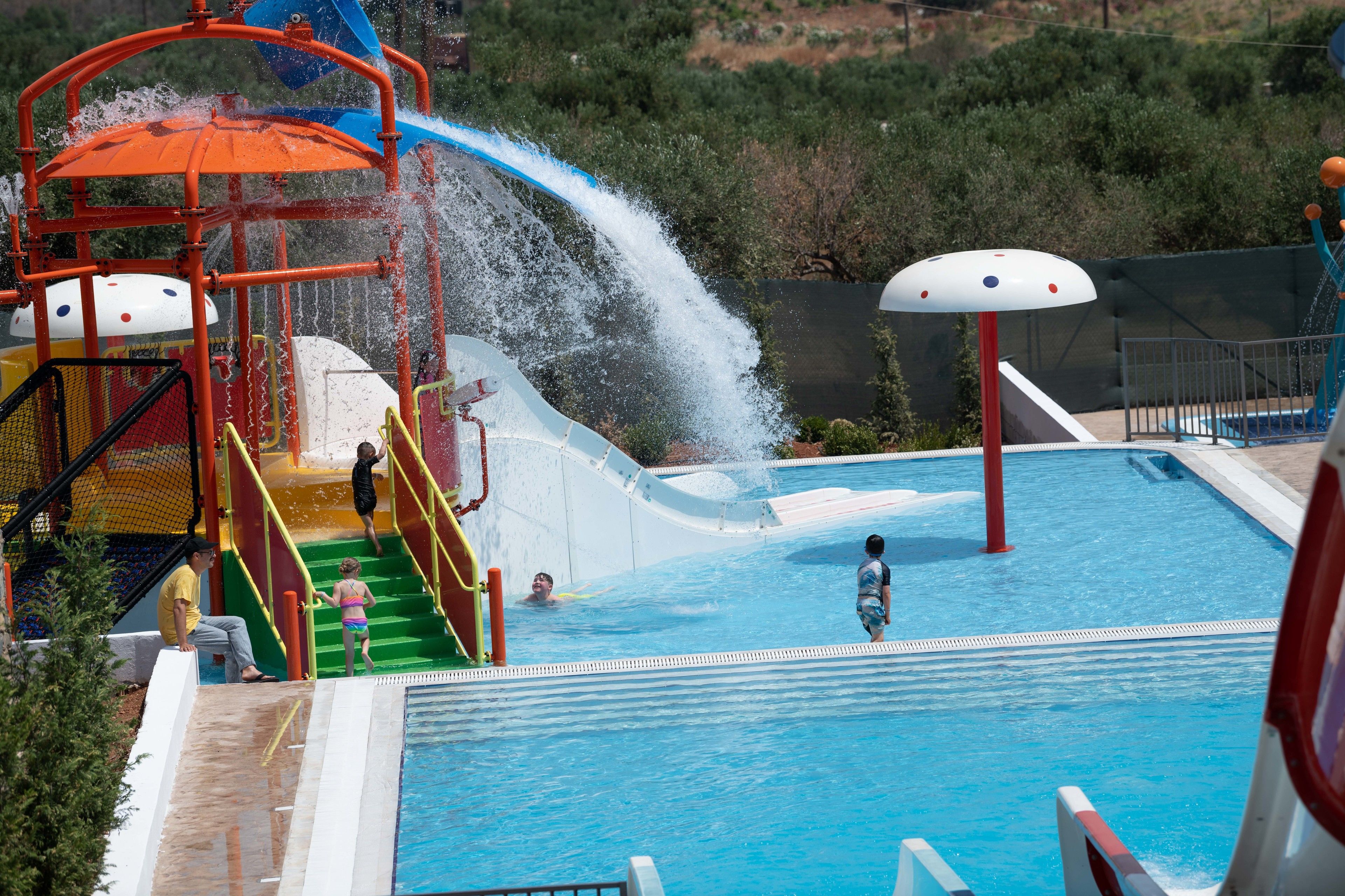 A water park with a pool, slides, and a water play area.