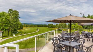 A balcony with outdoor seating overlooking a golf course. - Living Stone Golf Resort (Collingwood)