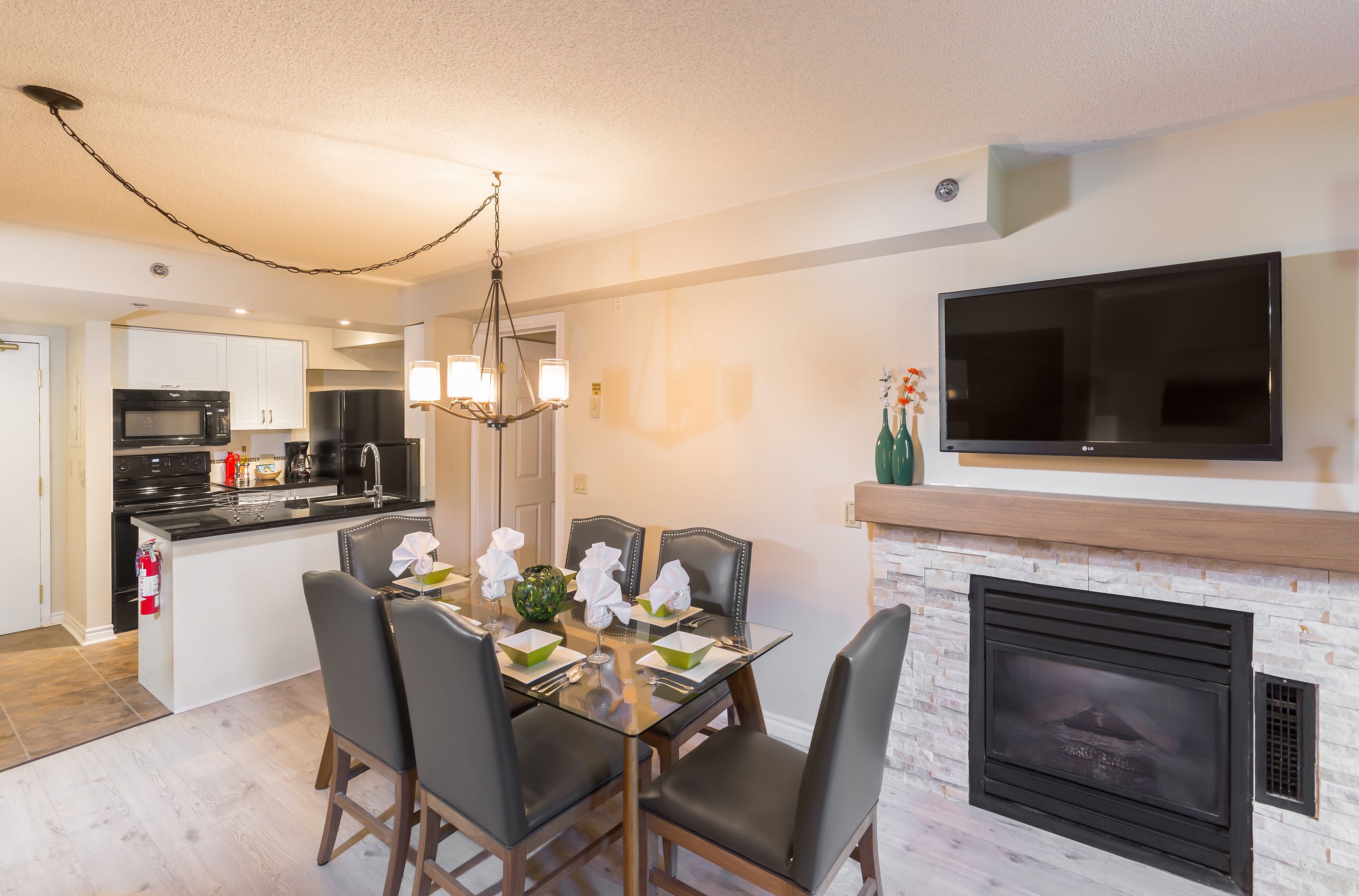 Una cocina moderna con comedor, televisor de pantalla plana y chimenea.