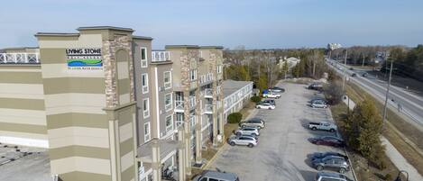 A multi-story building with a sign for 'Living Stone Golf Resort' and a parking lot with several cars.