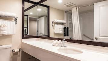 Un baño moderno con un espejo grande, un lavamanos y un inodoro.