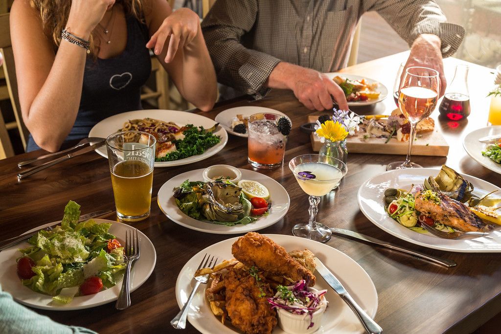 A dining table with various dishes, drinks, and utensils.
