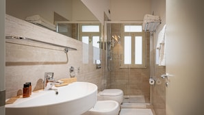 A modern bathroom with a large sink, toilet, and glass shower enclosure. - Sabbie d'Oro (Giardini Naxos)