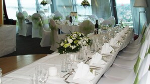 A banquet table set for a formal event with white tablecloths, glassware, and floral centerpieces. - Holiday Inn Birmingham North - Cannock by IHG (Cannock)