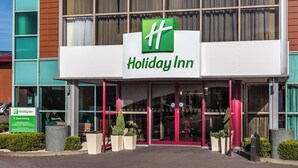 A Holiday Inn hotel entrance with a clear sign, automatic doors, and a guest parking sign. - Holiday Inn Birmingham North - Cannock by IHG (Cannock)