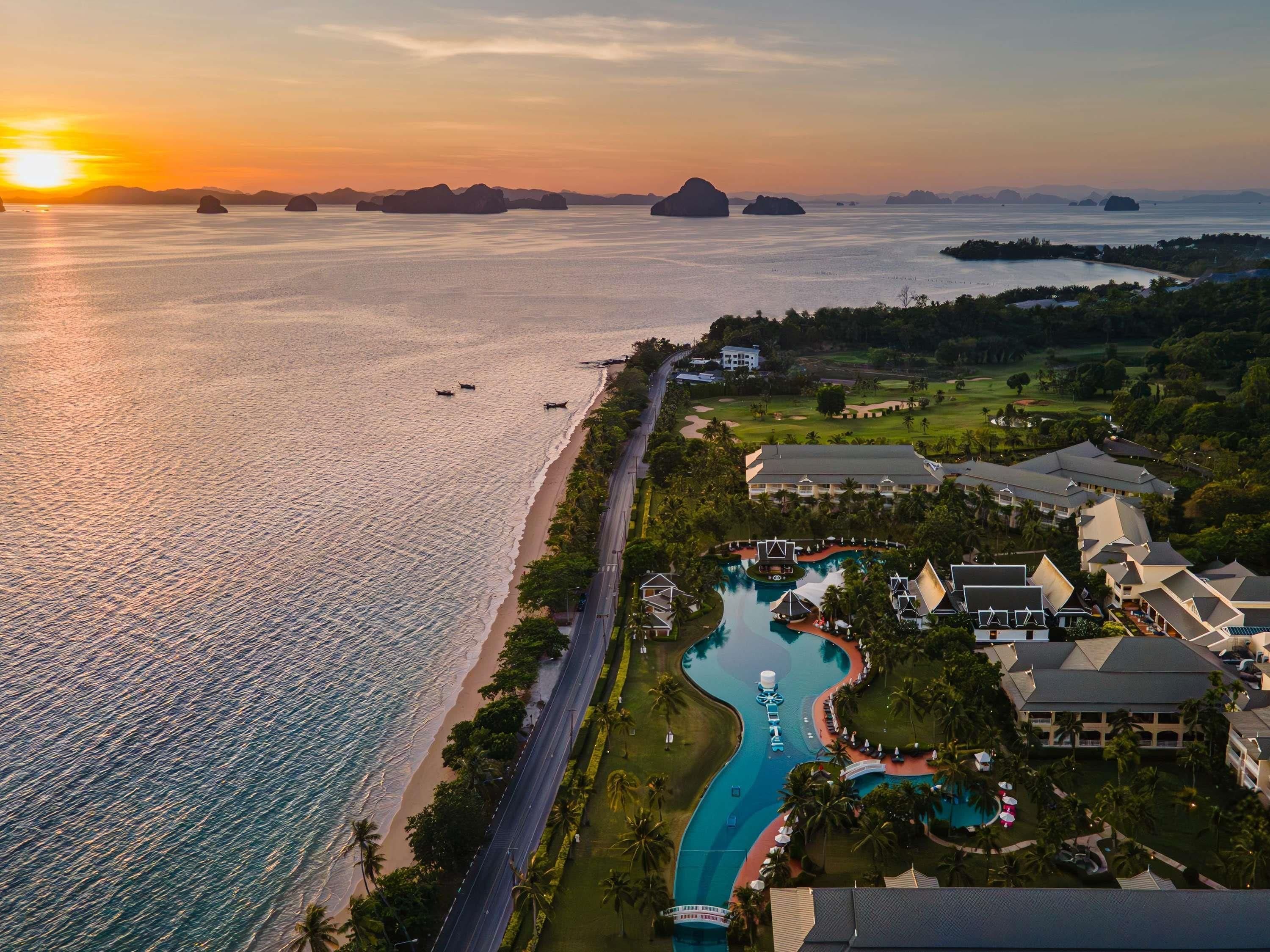 A resort with a swimming pool, beachfront, and golf course.