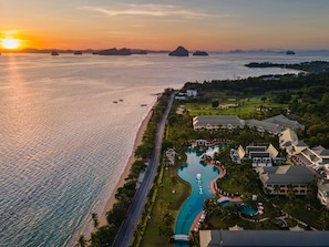 Een resort met zwembad, strand en golfbaan.