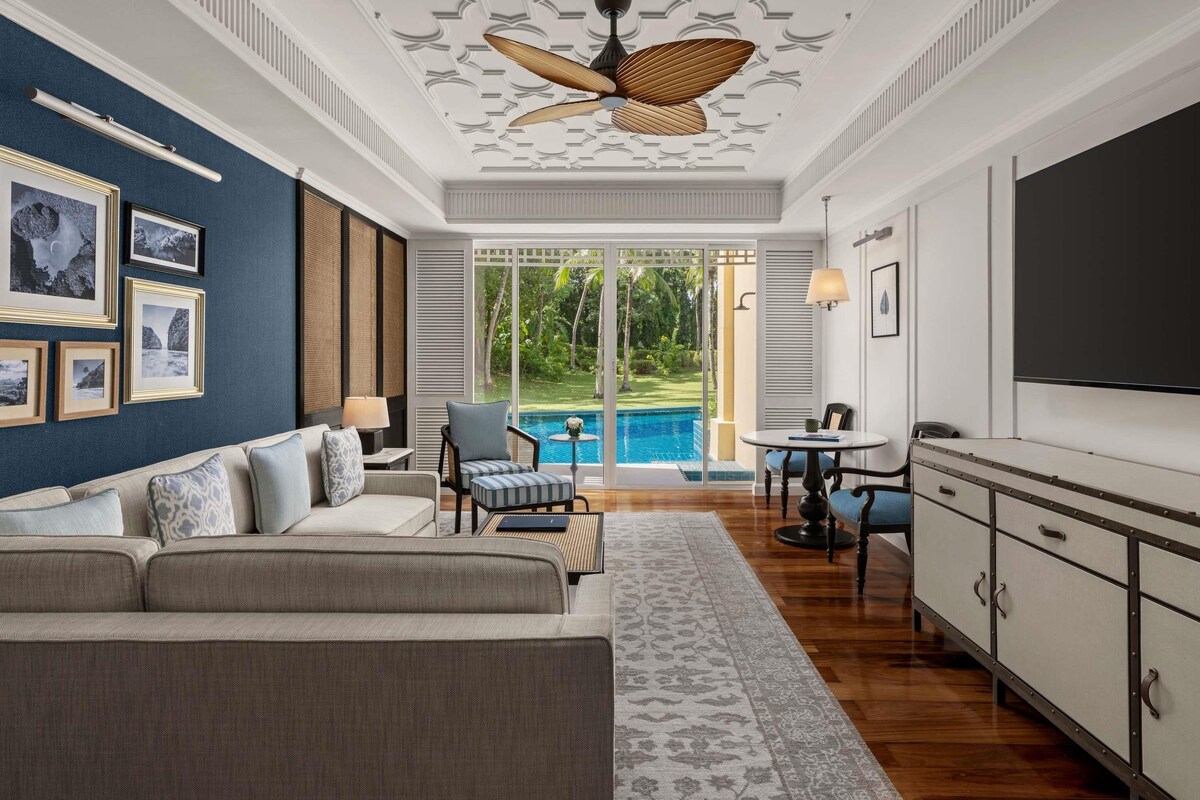 Un salon spacieux avec un grand canapé, un coin repas et une vue sur une piscine.