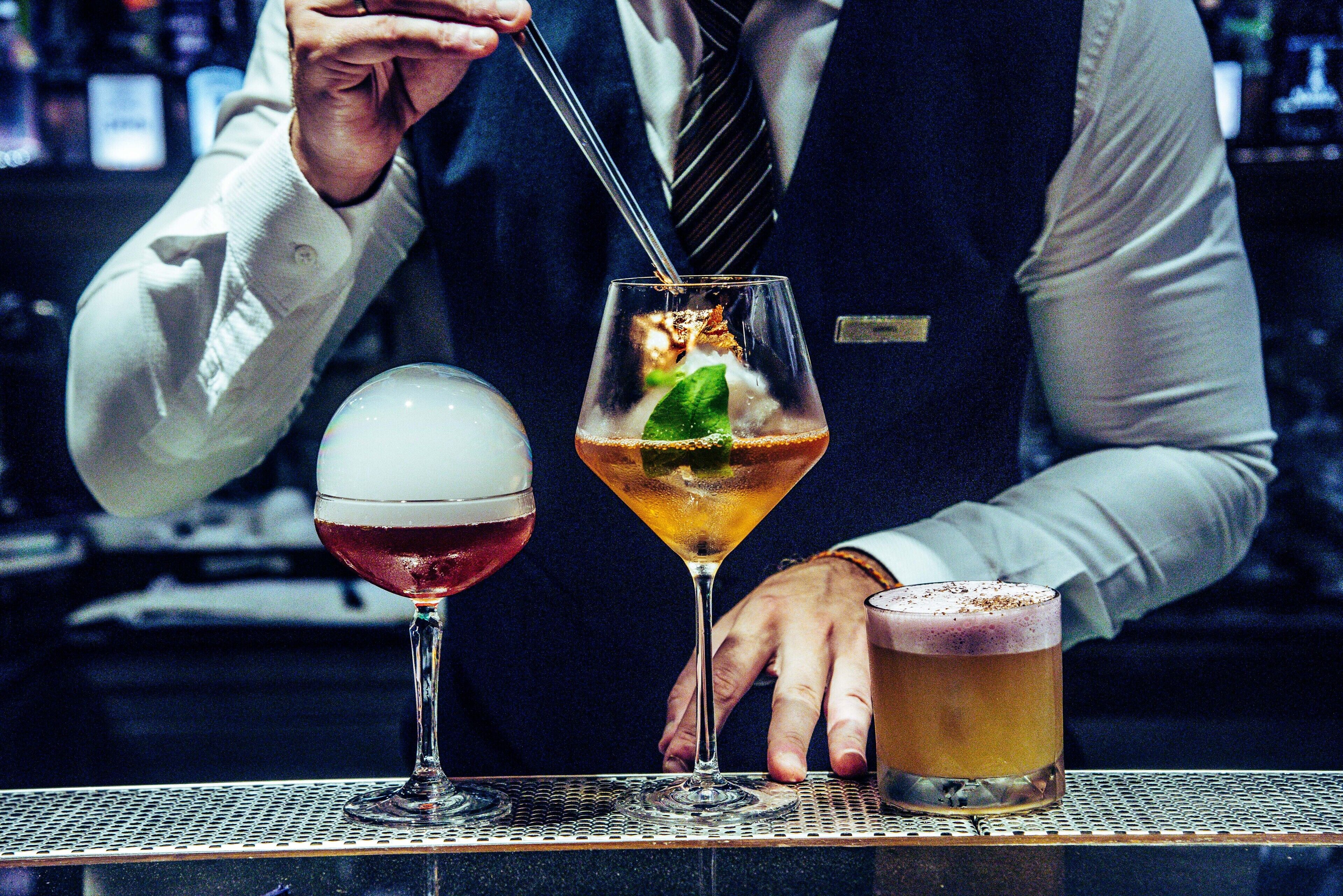 Un cantinero preparando bebidas en la barra.