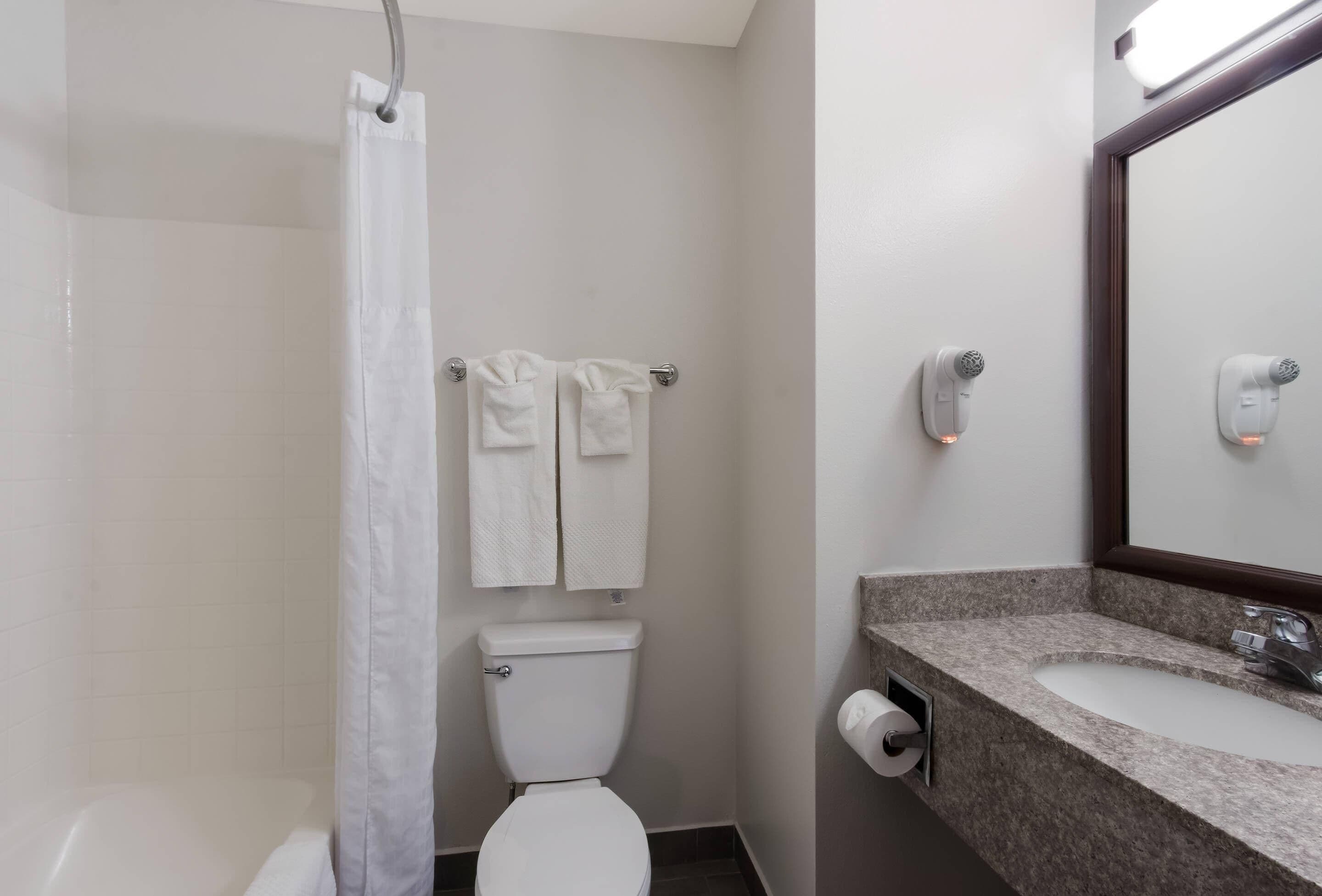 Un baño con ducha, inodoro y lavabo.