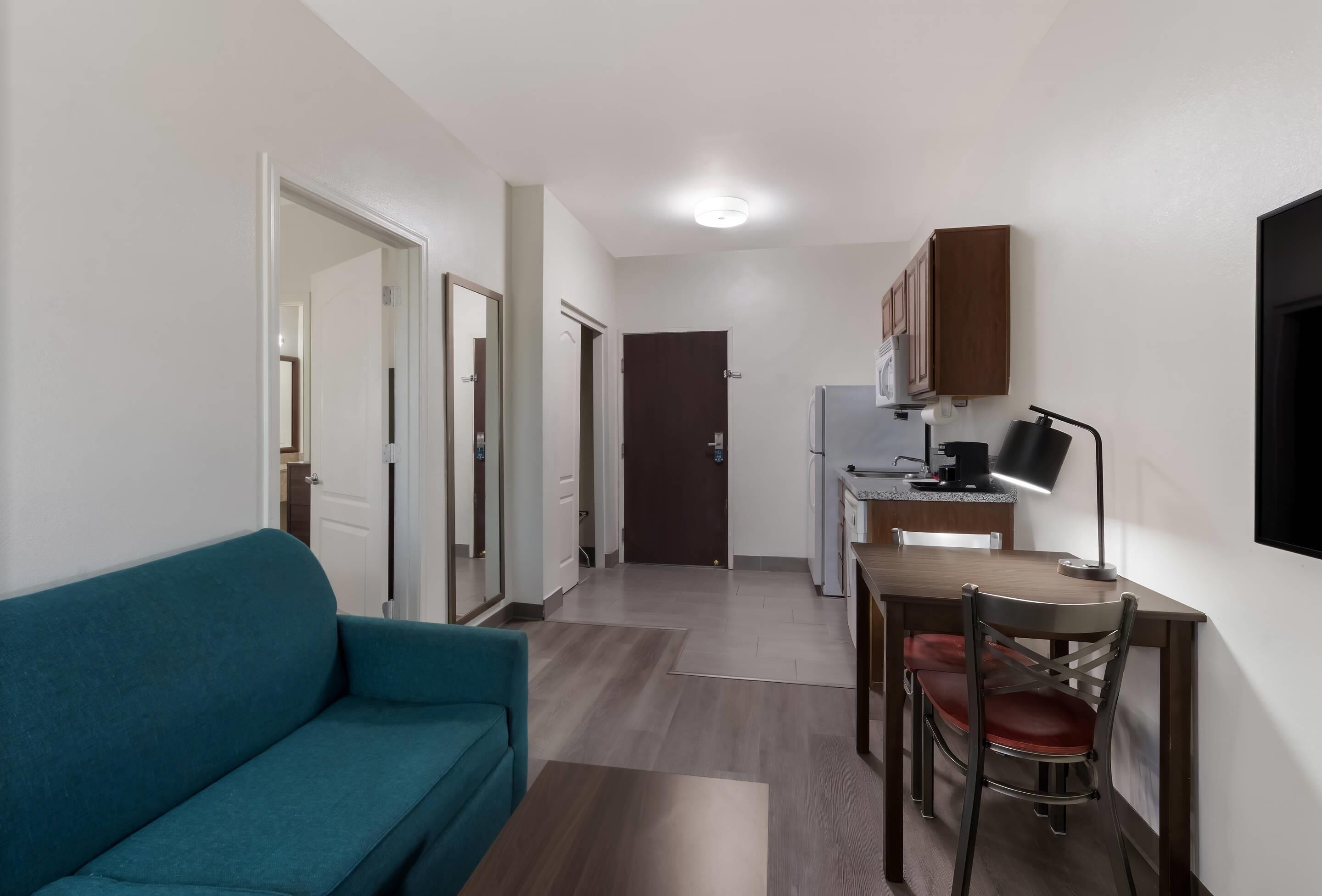 A compact living space with a kitchenette, a dining area, and a sofa.