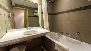Ein Badezimmer mit Waschbecken, Spiegel, Dusche und Toilette.