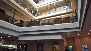 A multi-level atrium with a glass ceiling, modern furnishings, and a reception desk. - MajesticHouse Conference & Restaurant (Castenedolo)