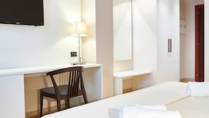 A hotel room with a bed, a desk, a chair, a lamp, and a TV. - MajesticHouse Conference & Restaurant (Castenedolo)