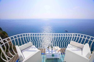 Suite junior, balcón, vistas al mar | Ropa de cama hipoalergénica, minibar, caja fuerte y escritorio