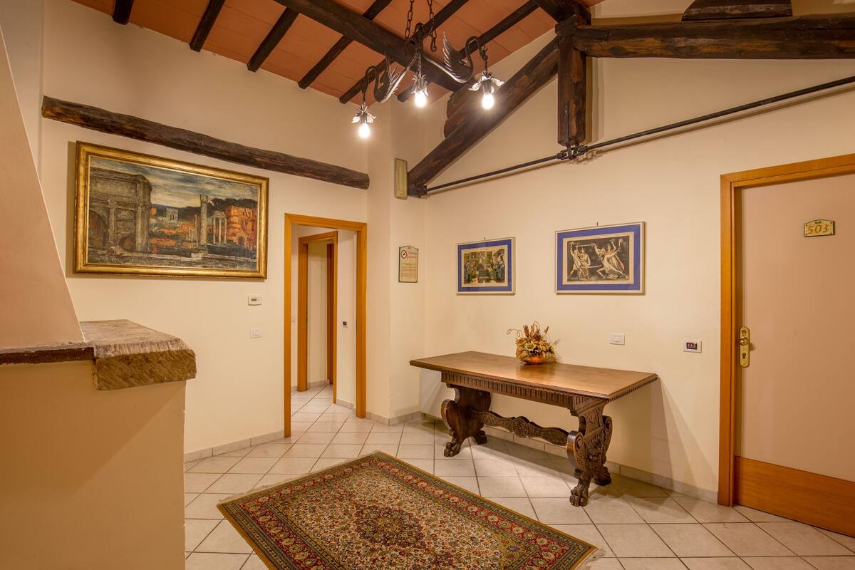 Un couloir avec une table en bois, un tapis et des tableaux encadrés accrochés aux murs.